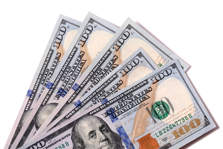 Fan of $100 dollar bills isolated against white with shadow.