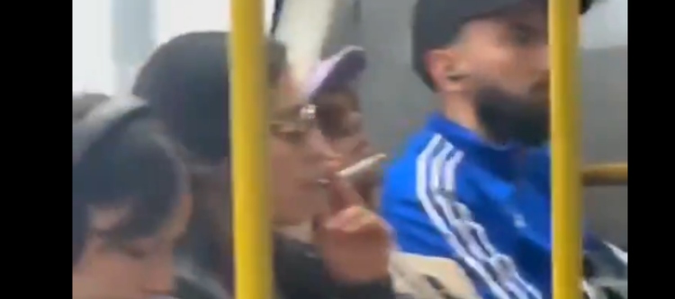 Pasajera enciende un cigarrillo dentro de un bus de TransMilenio en plena Carrera 30